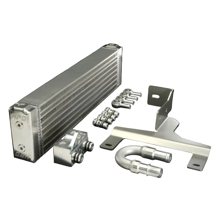 Collection of automotive parts including a metal radiator, brackets, and pipes on a black background.